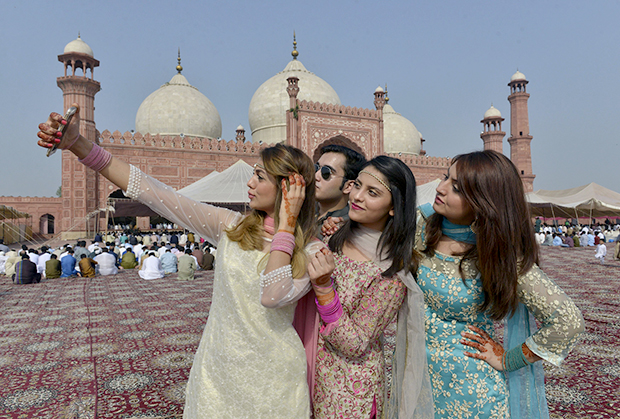 Pakistani Muslims pose for selfie after attending Eid al-Adha prayers in Lahore on September 13, 2016. Muslims across the world celebrate the annual festival of Eid al-Adha, or the Festival of Sacrifice, which marks the end of the Hajj pilgrimage to Mecca and in commemoration of Prophet Abraham's readiness to sacrifice his son to show obedience to God. / AFP PHOTO / ARIF ALI