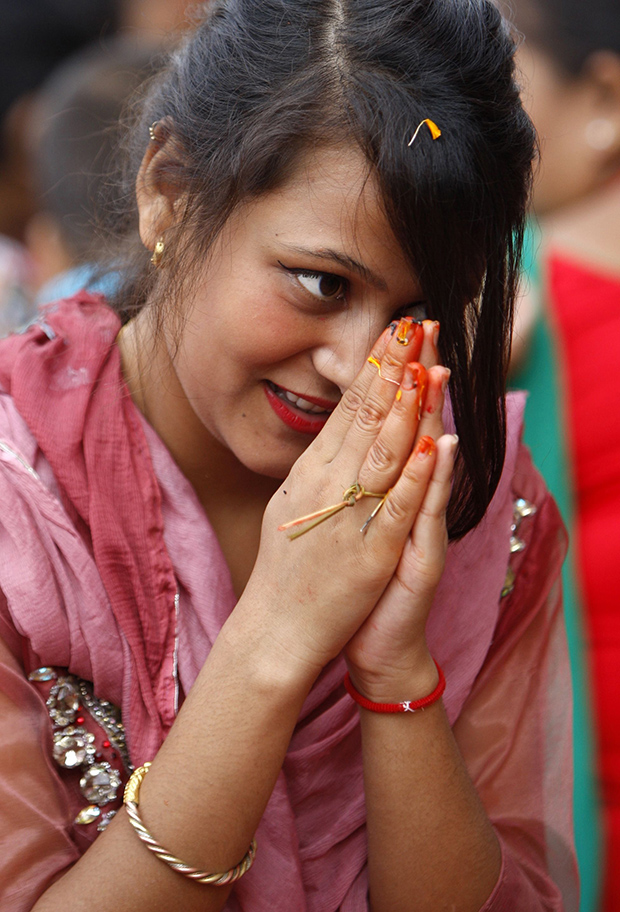 A Nepalese Hindu woman recites prayers led by a priest on the banks of the Bagmati River during the Rishi Panchami festival in Kathmandu on September 6, 2016. Rishi Panchami marks the end of the three-day long Teej Festival, celebrated in Nepal and some parts of India by married Hindu women by fasting during the day and praying for long lives for their husbands, while unmarried women wish for handsome husbands and happy conjugal lives. / AFP PHOTO / PRAKASH MATHEMA